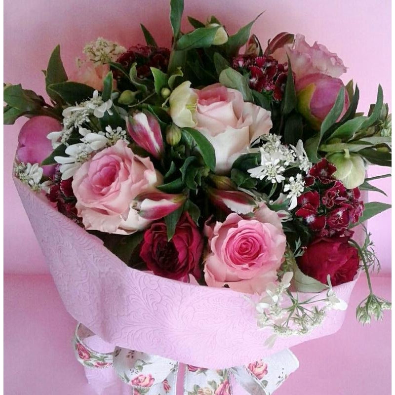 Love & Hugs.  A water box trimmed with a soft wrap for easy care, full of seasonal blooms centred around roses, invoking the best for your loved one, strong but soft, beautiful and enduring. 