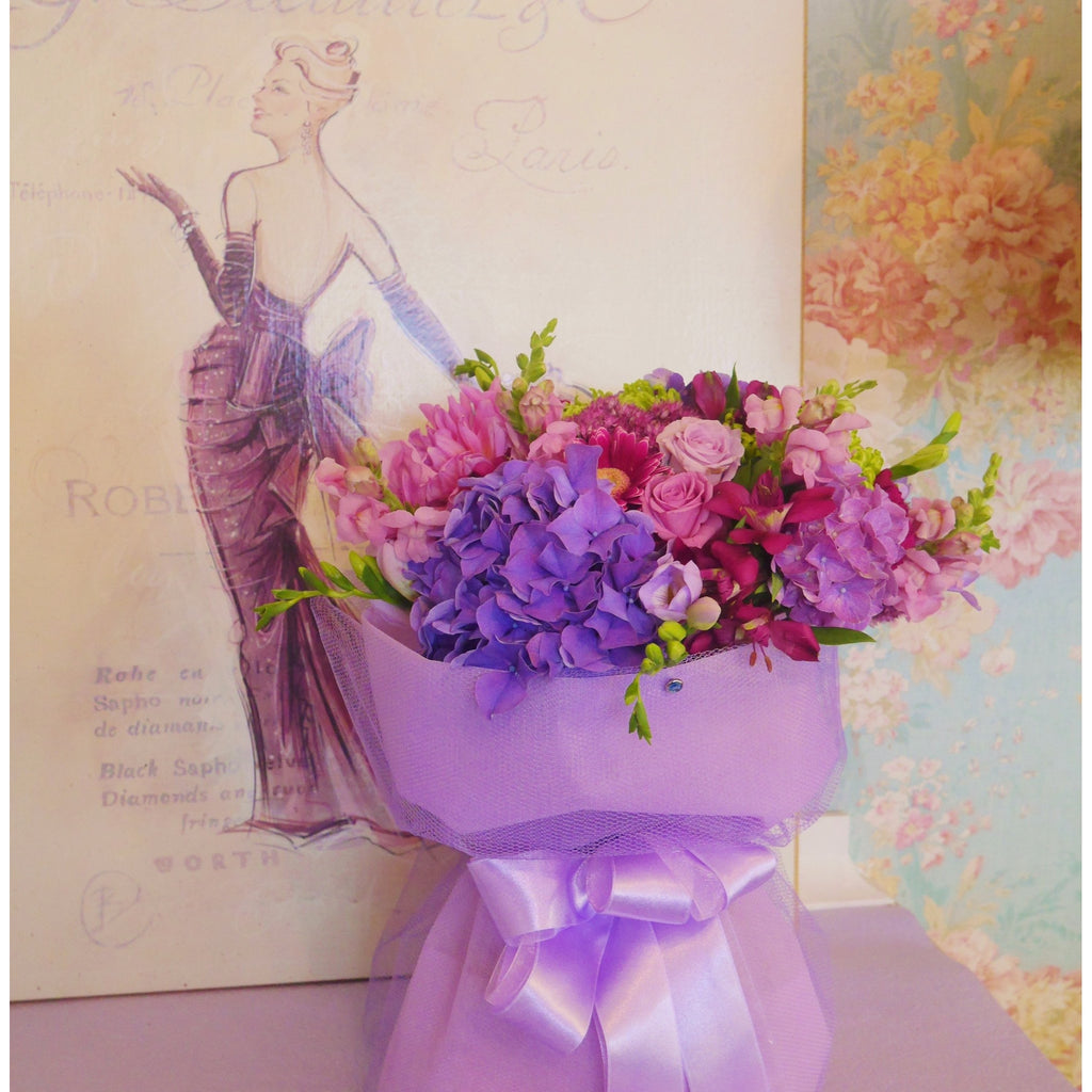 Luscious Lilac Jewel.  A beautiful coloured flower arrangement of lilac, deep cerise and mauve, a true jewel mix. Delivered in a water box and stylishly finished with a complimentary lilac wrap and ribbon. 